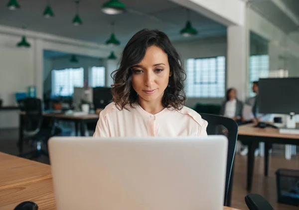 Fokuserad Affärskvinna Arbetar Bärbar Dator Medan Sitter Vid Sitt Skrivbord — Stockfoto