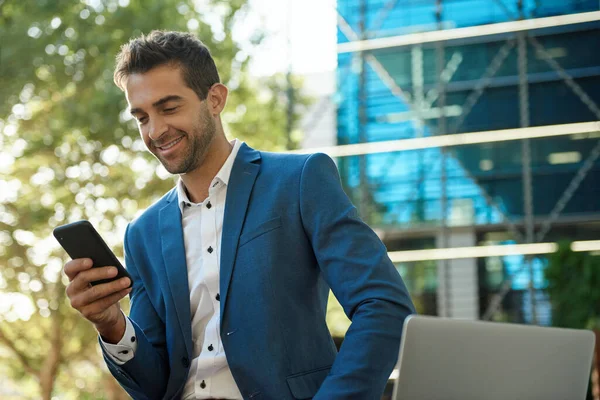 Jovem Empresário Sorrindo Lendo Uma Mensagem Texto Seu Celular Enquanto — Fotografia de Stock