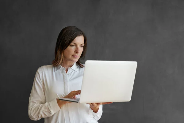 Bizneswoman Pracuje Laptopie Który Trzyma Stojąc Przed Pustą Tablicą Biurową — Zdjęcie stockowe