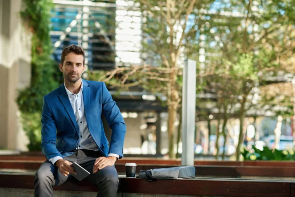 彼のオフィスビルの外のベンチに座って デジタルタブレットで作業している自信のあるビジネスマンの肖像画 — ストック写真