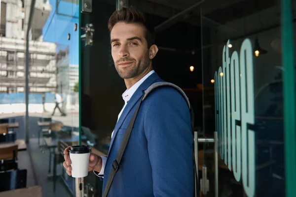 Portret Młodego Biznesmena Stojącego Przy Drzwiach Kawiarni Filiżanką Kawy Wynos — Zdjęcie stockowe