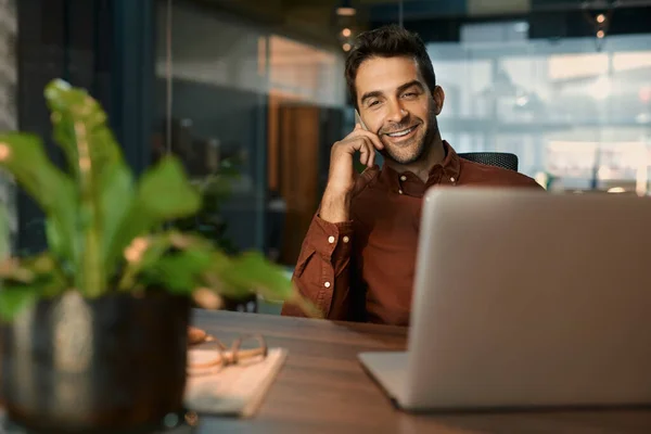 Uomo Affari Sorridente Che Parla Cellulare Mentre Lavora Portatile Alla — Foto Stock