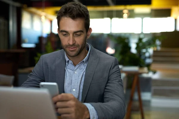 Jovem Empresário Checando Suas Mensagens Celular Trabalhando Laptop Sua Mesa — Fotografia de Stock