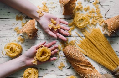 Ahşap masa, ekmek, makarna güzel kız elinde makarna çeşitleri