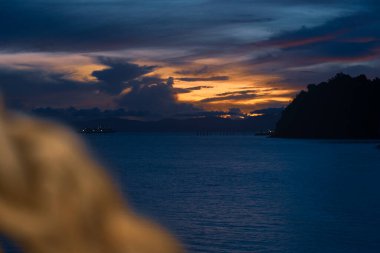 Denizden yükselen güneş. Renkli bulutlu gökyüzü ve güneş ışınları
