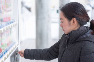 Asyalı kadın Gezgin otomat kış Japonya üzerinden ürün seçimi.
