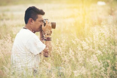 Genç Asyalı adam alarak fotoğraf dijital SLR dijital fotoğraf makinesi ile açık havada. Kahve dükkanında eğleniyor genç neşeli kadın turist. Yaşam tarzı portre kavramı.