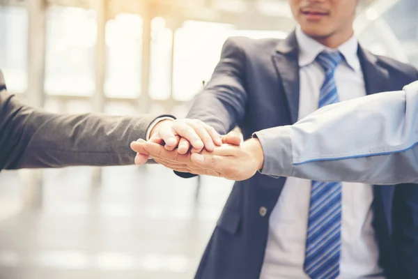 Teamwork Concept. Group of young businessman teamwork touching shaking hands together.