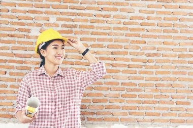 Genç güzel mühendis çalışma Holding bina planları Sarı kask giymek.