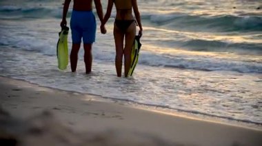 Canlı gökyüzü ile gün batımında tropikal yaz plajda balayı tatil gezisinde Siluet Çift sevgilisi. Açık hava seyahat yaşam tarzı kavramı. yaz aylarında manzara sahilde deniz plaj dalga