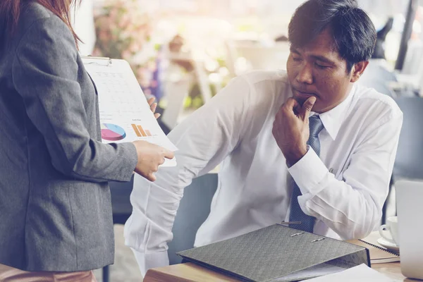 Asian Businessman thinking profit and loss about new project. Young secretary showing financial report.