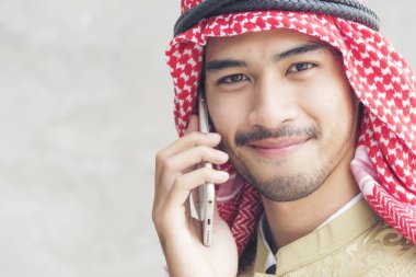 Yakışıklı modern Arap adam akıllı tablet tutarak kullanarak.