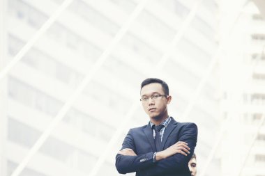 Lider genç yönetici işadamı güçlü ve liderlik göstermek için modern şehir arka planda ayakta. İş Lideri Kavramsal İmaj.