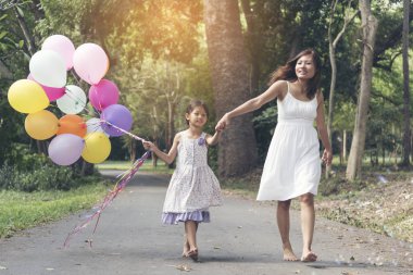 Renkli balon ile birlikte el ele sevimli sevimli kız.