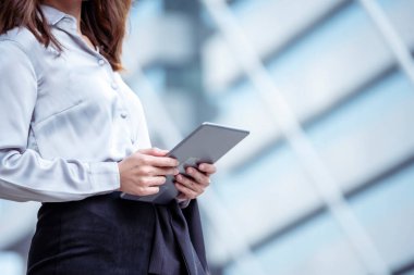 Asyalı bir kadın akıllı telefondan tablet alışverişi yapıyor ve gülümsüyor. Cep telefonu tutan Asyalı kadının mutluluğu İnternet alışveriş sitesinden gelen postaları kontrol etmesi Blog vlog sosyal medya yazısını okuması