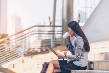 Asyalı bir kadın akıllı telefondan tablet alışverişi yapıyor ve gülümsüyor. Cep telefonu tutan Asyalı kadının mutluluğu İnternet alışveriş sitesinden gelen postaları kontrol etmesi Blog vlog sosyal medya yazısını okuması