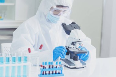 Bilim adamı covid-19 virüs kimya araştırması biyoteknoloji antikor örneği laboratuvarı virüse karşı aşı üretiyor. Bilim adamı mikroskoba bakıyor, bilim test tüpü kimya laboratuvarını analiz ediyor.