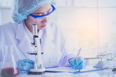 Kadın bilim adamı mikroskopa bakar, bilim test tüpü laboratuvar araştırma deneylerindeki bilimsel örnekleri analiz eder ve biyoteknoloji virüse karşı aşı üretir. Kimya bilimi laboratuarı kavramı