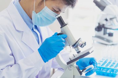 Bilimadamı covid-19 virüs antikor örneği laboratuvar araştırma biyoteknisyeni virüse karşı aşı üretiyor. Bilim adamı mikroskoba bakıyor, bilim test tüpü kimya laboratuvarını analiz ediyor.