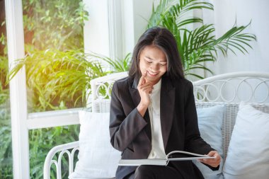 Asyalı bir kadın akıllı tablet el işaretli ekranlı dijital tablet üzerinde online telefon alışverişi yapıyor. Akıllı telefon tutan kadın İnternet alışveriş sitesinde e-postaları kontrol ediyor.