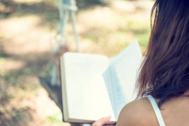 Rahatla kadın, elinde İncil 'le dışarıda okunan parkta yeşil bahçede oturan kadın. Sonbahar sezonunda ev bahçesinde açık kitap okuyan genç bir kadın rahatlaması. Zeki, güzel bir kadın yaşam tarzı öğrencisiyim..