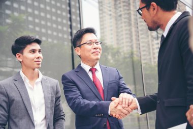 Ortak İşletme Vakfı Takım Çalışması Ortaklığı. Sanayi müteahhidi yumruk tokuşturma görevi. Görev ekibi, İnsan Yumruğu 'nun El sıkışması grubuyla buluşuyor. Business Trust takım çalışması kavramı