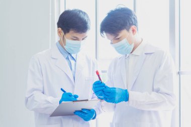 Bilim adamı covid-19 virüs antikor araştırma laboratuvarı biyoteknoloji deneyleri virüse karşı aşı üretiyor. Bilimadamları mikroskop deneyine bakıyorlar. Laboratuvar, deney tüpü kimya laboratuvarı.