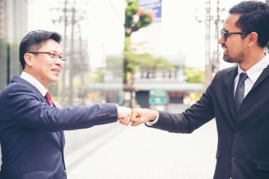 Ortak İşletme Vakfı Takım Çalışması Ortaklığı. Sanayi müteahhidi yumruk tokuşturma görevi. Görev ekibi, İnsan Yumruğu 'nun El sıkışması grubuyla buluşuyor. Business Trust takım çalışması kavramı