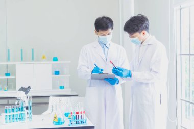 Bilim adamı covid-19 virüs antikor araştırma laboratuvarı biyoteknoloji deneyleri virüse karşı aşı üretiyor. Bilimadamları mikroskop deneyine bakıyorlar. Laboratuvar, deney tüpü kimya laboratuvarı.