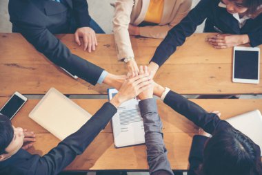 Takım çalışması kavramı. Çeşitli insanlardan oluşan bir grup canlı yayında Ebeleme Takımı 'nın selamlama gücüne beşlik çakıyor. Birlikte çalışan çok ırklı insanlar grubu. İş Ekibi başarısında gönüllü işbirliği