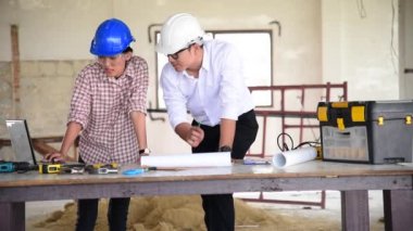 İnşaat mühendisi takım çalışması güvenlik ekibi, inşaat sahasında beyaz sarı şapkalı güvenlik ekipmanı tutuyor. Hardhat İnşaat Mühendisliği Mühendisliği Yöneticisini Koru