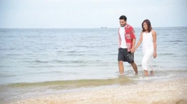 Balayı çifti aşığı kumsalda yürüyor romantik ilişki mutluluğu anı aşk yaşam tarzıyla. Sevgililer gününde sevgili olarak uzun bir kumsalda el ele yürür..