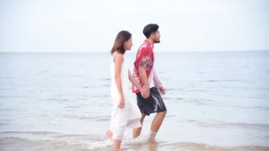 Balayı çifti aşığı kumsalda yürüyor romantik ilişki mutluluğu anı aşk yaşam tarzıyla. Sevgililer gününde sevgili olarak uzun bir kumsalda el ele yürür..
