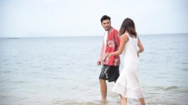 Balayı çifti aşığı kumsalda yürüyor romantik ilişki mutluluğu anı aşk yaşam tarzıyla. Sevgililer gününde sevgili olarak uzun bir kumsalda el ele yürür..
