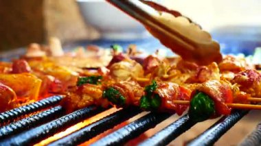 Barbekü ızgara et çubuğu ateşte, dışarıda da sıcak kömür var. Biftek ızgara piknik yemeği ve parti için domuz pastırması sosisi. 