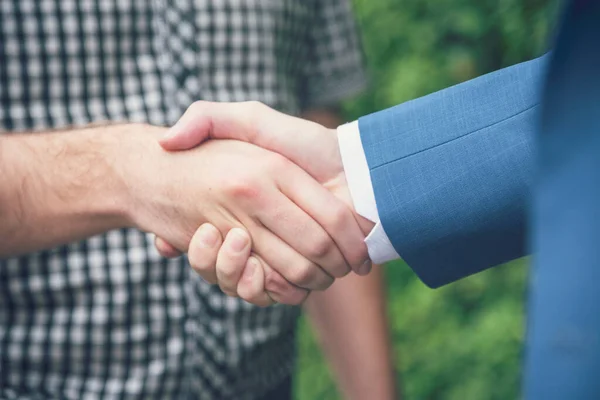 Business Partners shaking hands together in green ecosystem park introduce greeting start up new ecology project. Teams friendship shake hand together with teamwork partnership outdoor outside office.