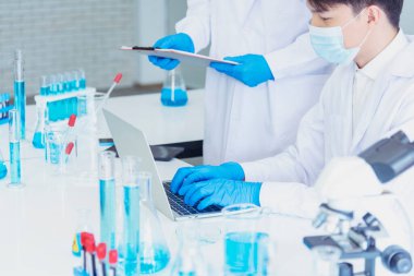 Bilim adamı covid-19 virüs kimya araştırması biyoteknoloji antikor örneği laboratuvarı virüse karşı aşı üretiyor. Bilim adamı mikroskoba bakıyor, bilim test tüpü kimya laboratuvarını analiz ediyor.