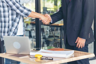 Diversity two business partners shaking hands together with business contract mergers and acquisitions. Close up honest hands business teams handshaking at office desk. Trust partnership shaking hands clipart