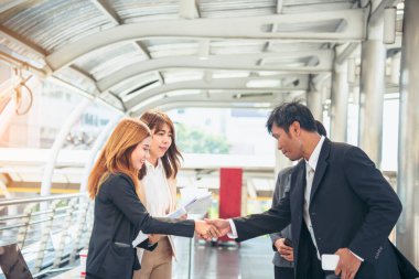 Takım İş Ortakları yeni projeyi başlatmak için el sıkışıyor. Ofis dışı modern şehir geçmişi dışında el sıkışan takım çalışması ortaklığı. İş adamı el sıkışması. İş konsepti