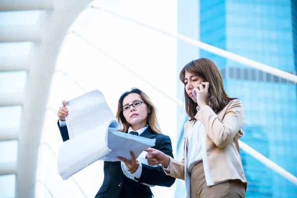 Happy entrepreneur asian businesswomen using smartphone dealing negotiate for startup business. Two partners enjoy good news from smartphone teamwork collaboration asian woman working together