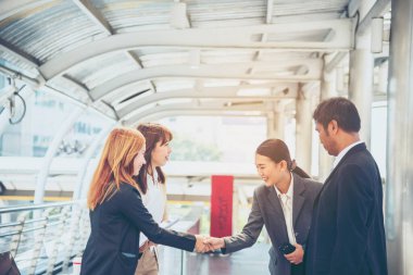 Takım İş Ortakları yeni projeyi başlatmak için el sıkışıyor. Ofis dışı modern şehir geçmişi dışında el sıkışan takım çalışması ortaklığı. İş adamı el sıkışması. İş konsepti