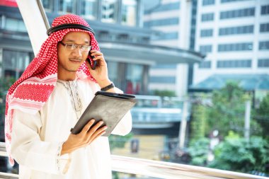 Akıllı telefon uygulaması kullanan İslami adam, ajandasını akıllı telefon Müslüman modern uae şehrine odaklıyor. Arap erkekleri tesettür ve Müslüman resmi giysileri giyer. Çevrimiçi yaşam tarzı mesajları gönderir.