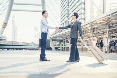 Takım İş Ortakları yeni projeyi başlatmak için el sıkışıyor. Ofis dışındaki kurumsal takım çalışması ortaklığı arka plan olarak modern şehir. El ele tutuşan iş adamı.