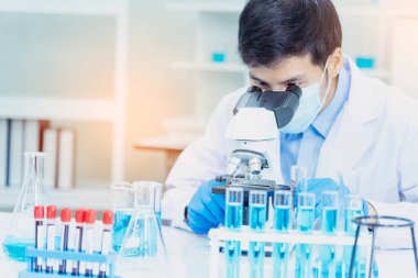 Bilim adamı covid-19 virüs kimya araştırması biyoteknoloji antikor örneği laboratuvarı virüse karşı aşı üretiyor. Bilim adamı mikroskoba bakıyor, bilim test tüpü kimya laboratuvarını analiz ediyor.