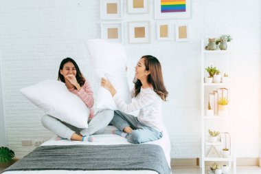 Lezbiyen çift yatakta homoseksüel mutlu bir yaşam sürüyor. İki güzel kız arkadaş konuşur, sarılır ve birlikte güler birbirlerine aşık olurlar. LGBTQ ilişki yaşam tarzı kavramı.