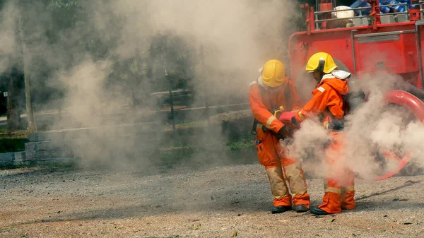 İtfaiyeci yangın hortumuyla, kimyasal köpüklü sprey motorla savaşıyor. İtfaiyeciler korunmak için kasketli, vücut korumalı üniformalı üniforma giyer. Yangın söndürücüde kurtarma eğitimi.