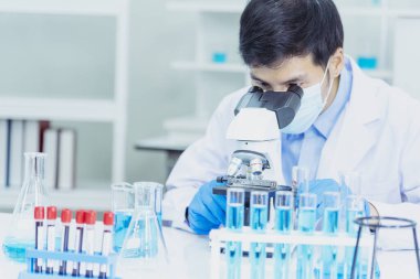 Bilim adamı covid-19 virüs kimya araştırması biyoteknoloji antikor örneği laboratuvarı virüse karşı aşı üretiyor. Bilim adamı mikroskoba bakıyor, bilim test tüpü kimya laboratuvarını analiz ediyor.