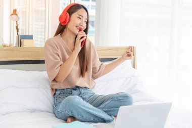 Sakin ol kadın yatakta okunan bir kitap tutuyor kulaklık kullanıyor, müzik dinliyor. Genç bir kadının rahatlaması, açık kitap gibi boş düşünceler okuyor. Mutluluk. Güzel kadın.