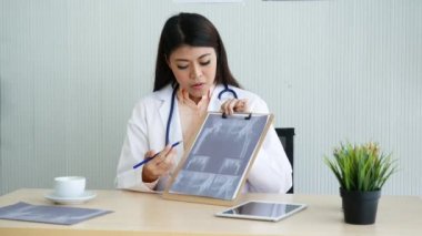 Kadın doktorlar, hastane meditasyon kliniğinde röntgen filmi kullanarak teşhise danışmanlık yapıyorlar. Doktor, dizüstü bilgisayarla tıbbi onkoloji terapisi için reçete yazıyor. Sağlık hizmetleri kavramı