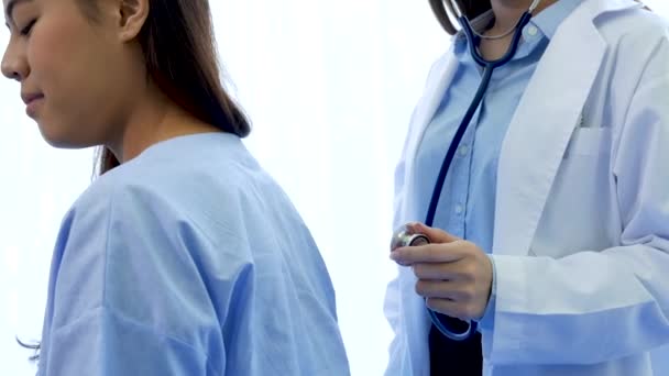 使用听诊器的亚洲女医生从肺病诊断学分析病人在医院的医疗护理治疗诊所使用手提电脑治疗乳腺癌 — 图库视频影像